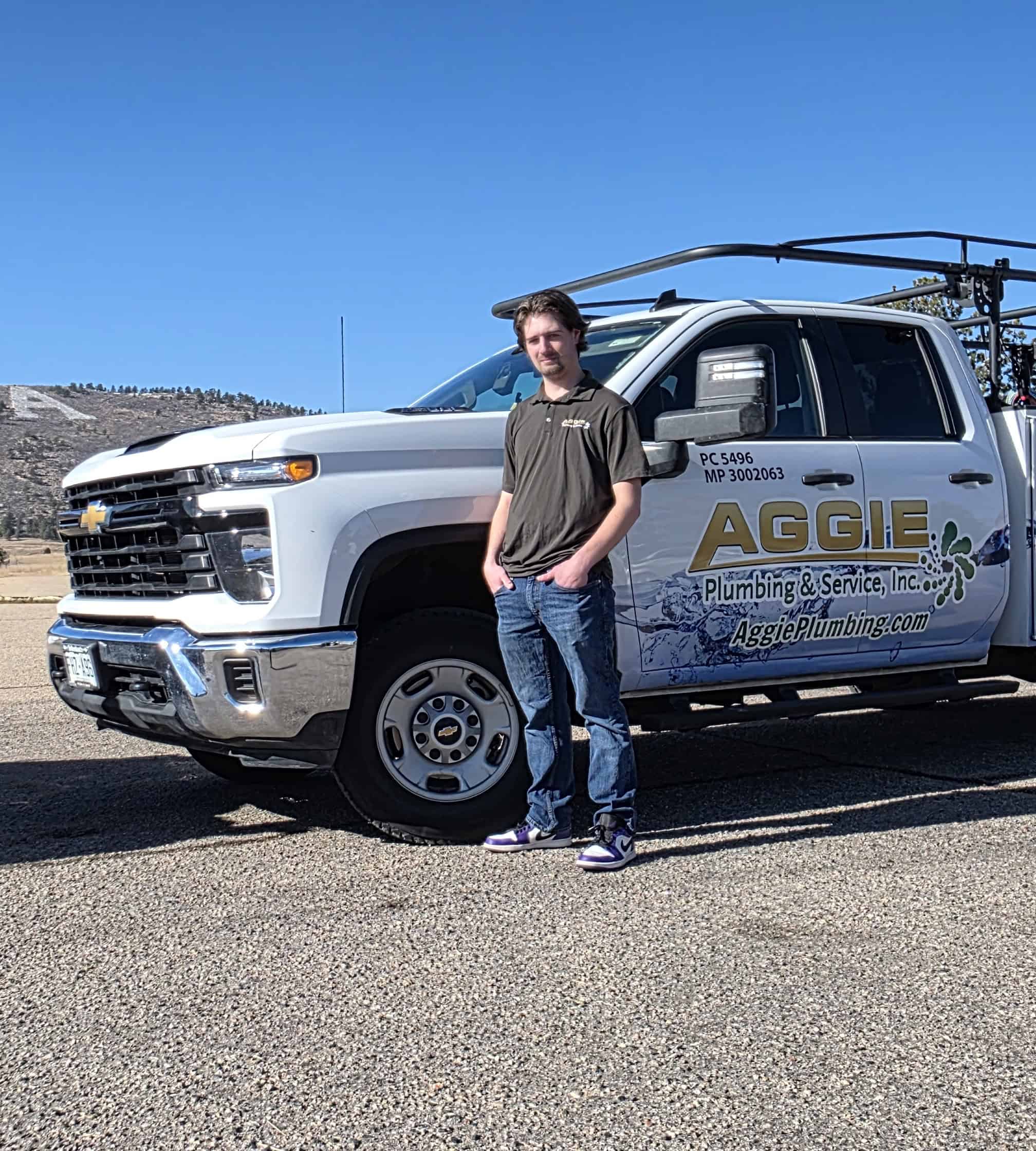 photo of the master plumber of aggie plumbing in front of a service truck